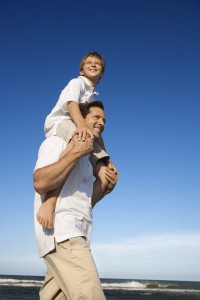Dad carrying son on his shoulders.