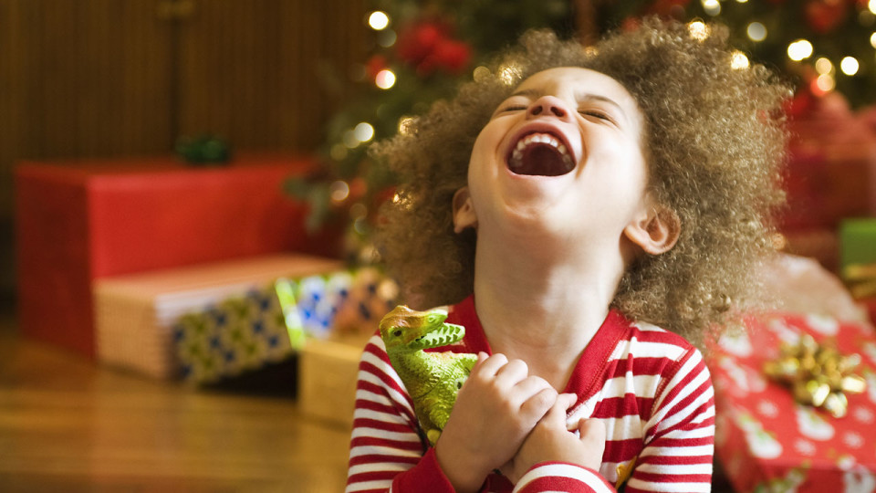 Excited mixed race boy opening Christmas gift